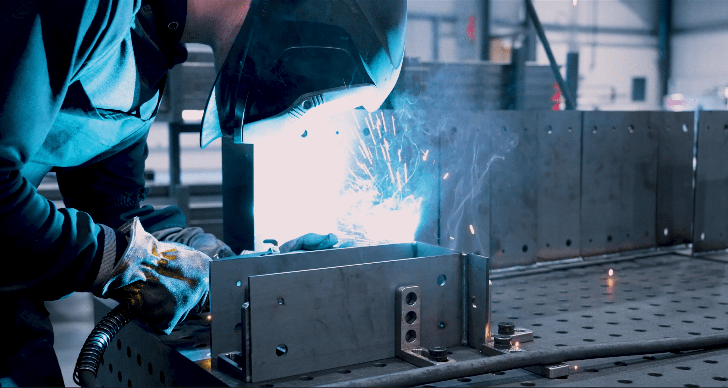man actively welding parts together